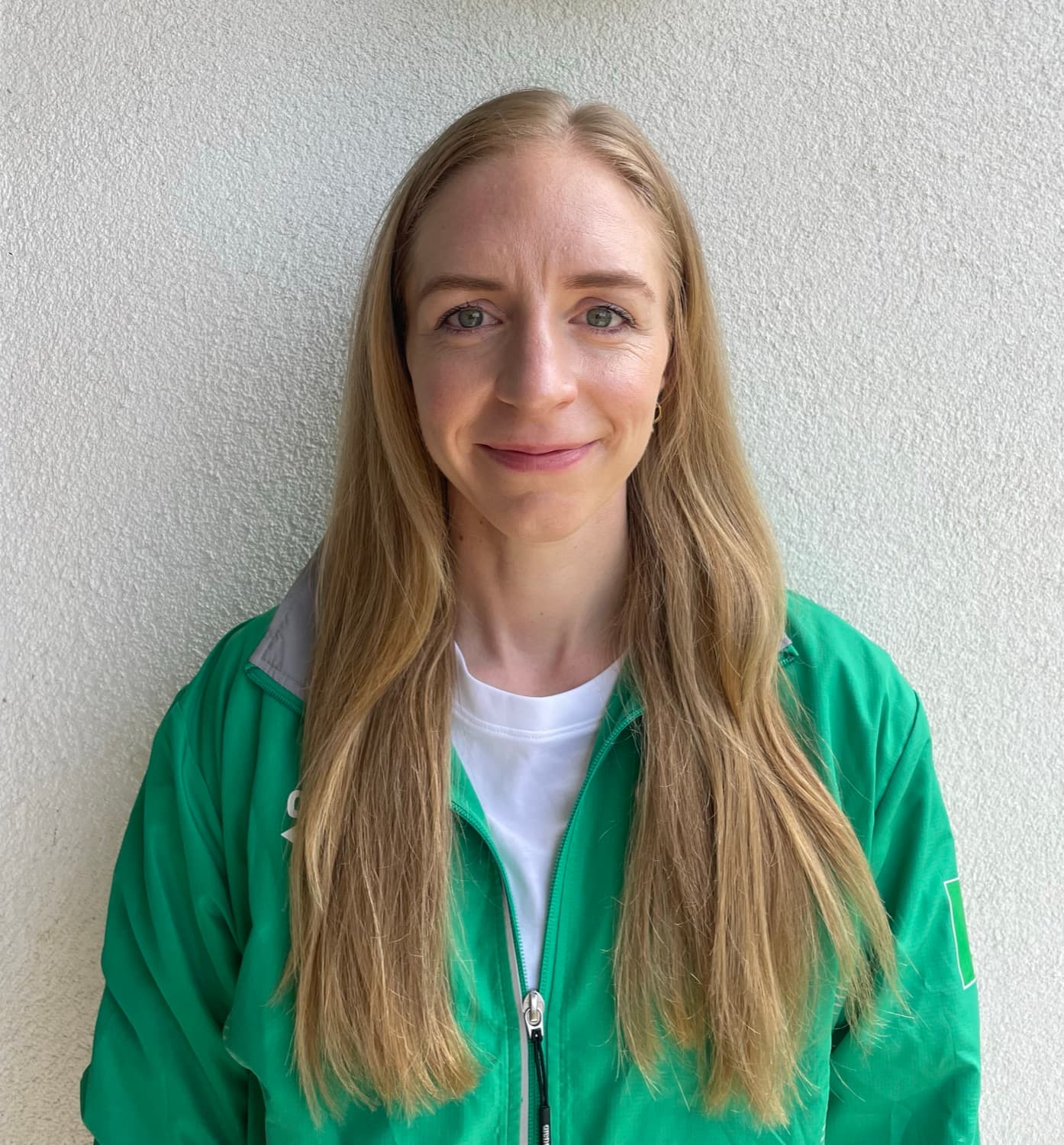 Portrait of Eimear Keane in her green Ireland team jacket, smiling at the camera